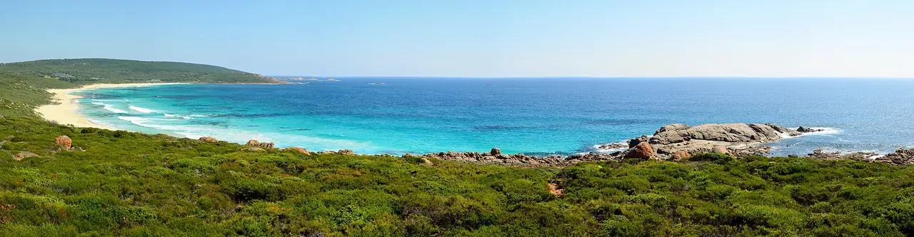 ปลาย Smiths Beach และโขดหินทางตอนเหนือของภูมิภาคมองจากเนินพืชพุ่ม ภาพพาโนรามาจาก Wikimedia Commons ผู้ถ่าย Bahnfrend สัญญา CC BY-SA 4.0 ถ่ายปี 2015