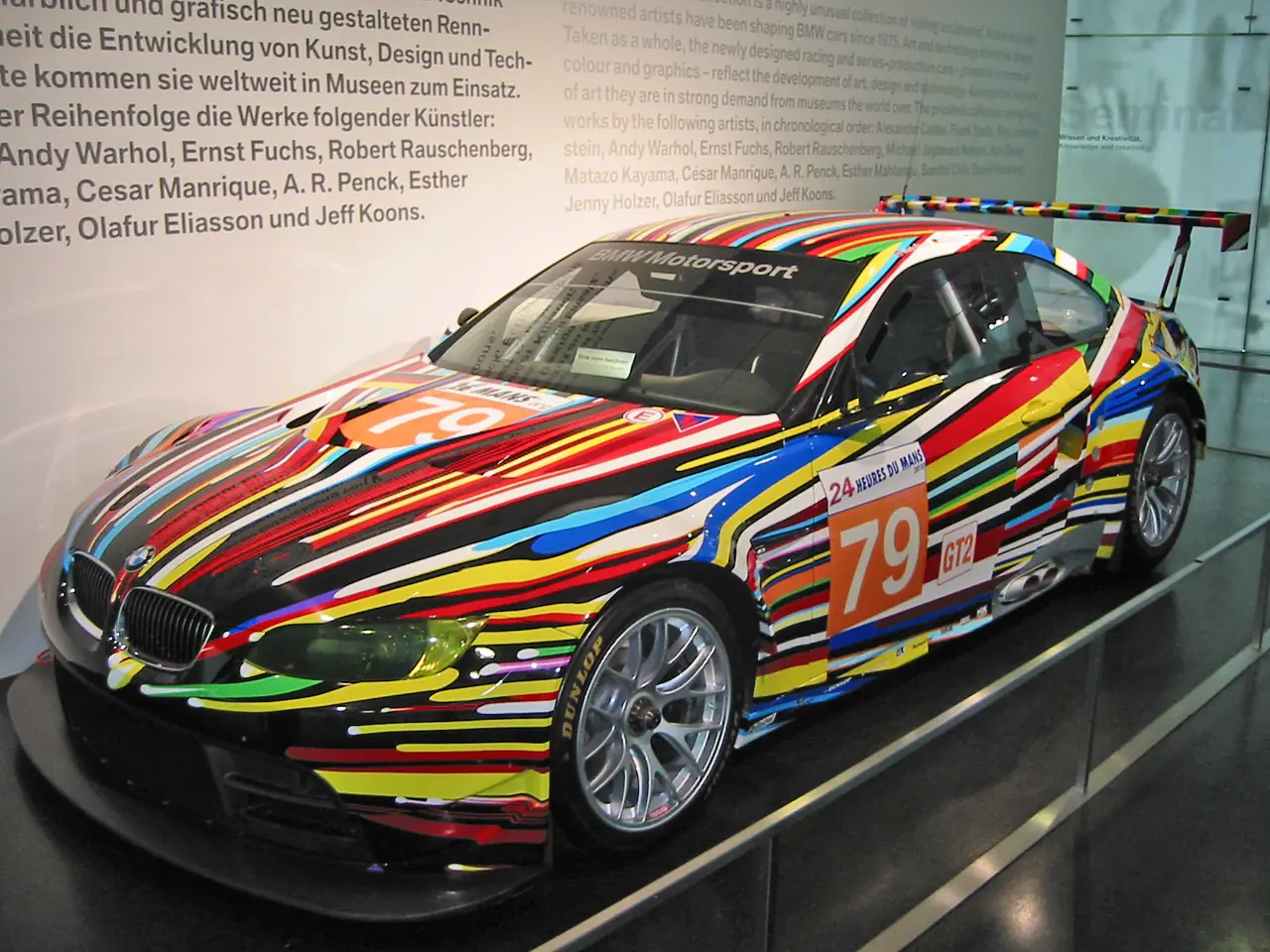BMW M3 GT2 Art Car ลายสีสดของ Jeff Koons ภาพจาก Wikimedia Commons ผู้ถ่าย Olli1800 สัญญา CC BY-SA 3.0 ปีที่ถ่ายไม่ระบุ รถอาจไม่ได้ตั้งโชว์ในวันที่คุณไป
