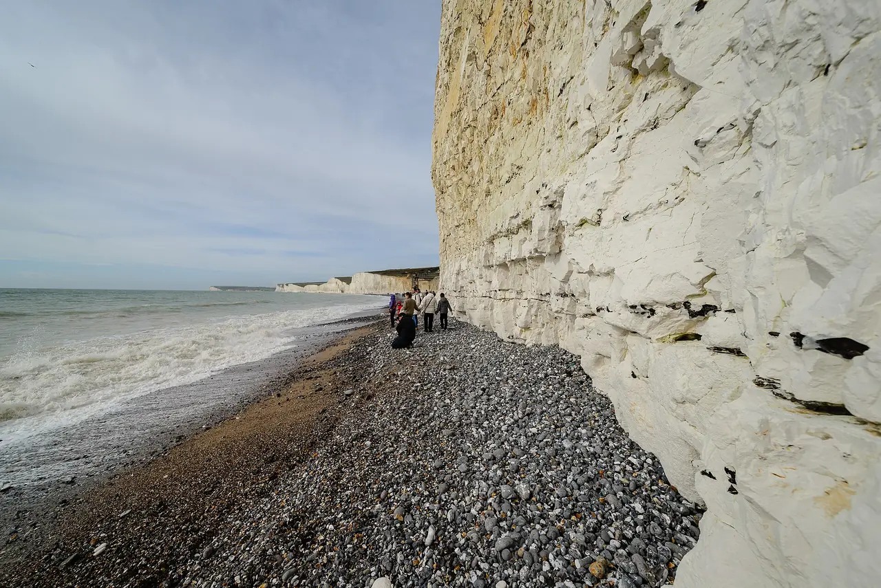 ชายหาดกรวดที่ Birling Gap มองเห็นหน้าผาชอล์ก ภาพจาก Wikimedia Commons ผู้ถ่าย Arild Vågen สัญญา CC BY-SA 4.0 ถ่ายเดือนมีนาคม 2017 Birling Gap อยู่ใกล้ Seven Sisters ทางตะวันออก