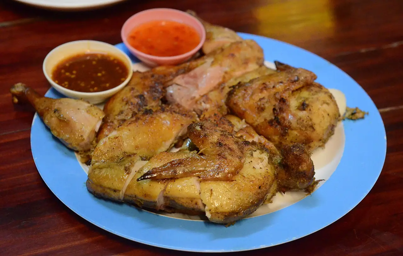 ไก่ย่างหั่นชิ้นบนจานสีฟ้า มีน้ำจิ้มสองถ้วย ภาพจาก Wikimedia Commons ผู้ถ่าย Takeaway สัญญา CC BY-SA 3.0 เป็นภาพไก่ย่างแบบไทยทั่วไป ไม่ใช่ร้านใดในโคราช ใช้ประกอบเรื่องไก่ย่างที่มิชลิน ไกด์ลงสามร้านในตัวเมือง