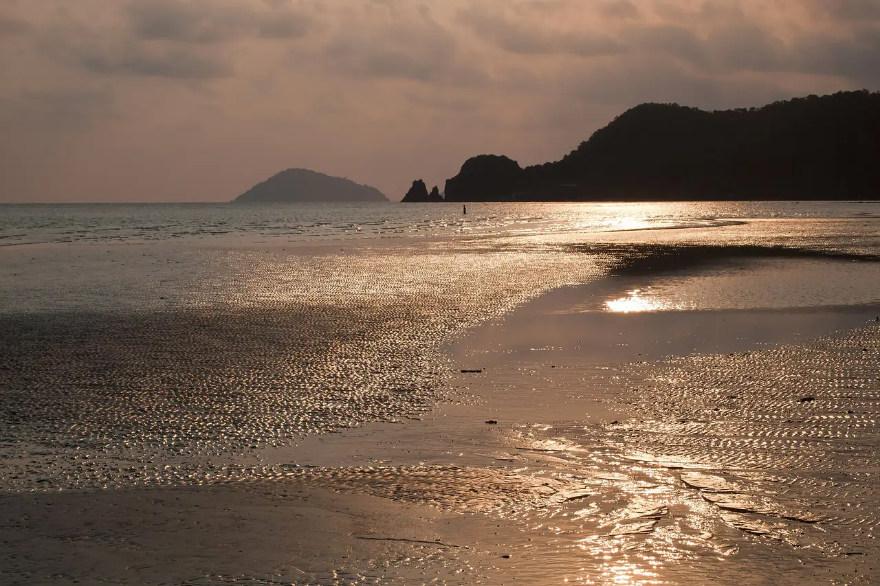 หาดทรายเปียกสะท้อนแสงตอนพระอาทิตย์ใกล้ตกและเงาเกาะเล็กไกล ๆ ที่เกาะหมาก ภาพจาก Wikimedia Commons ผู้ถ่าย Vyacheslav Argenberg สัญญา CC BY 4.0 ไม่ระบุอ่าว เป็นภาพประกอบบรรยากาศ