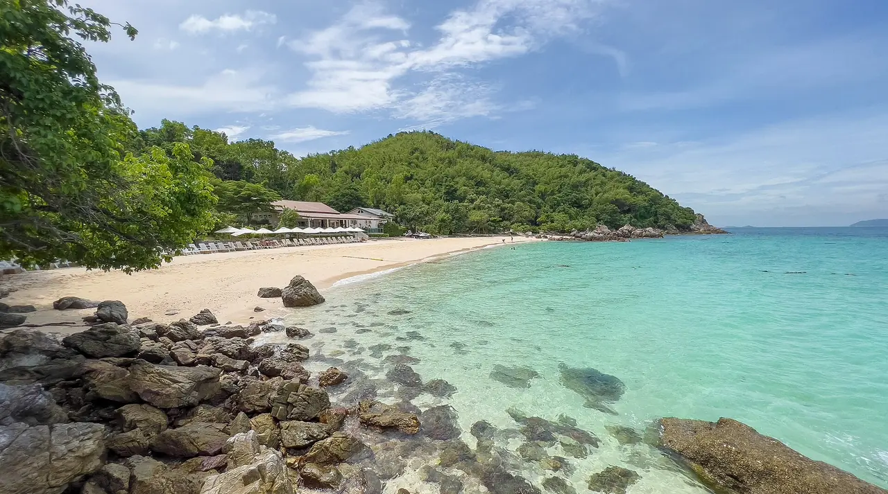หาดตายาย (Ta Yai Beach) เกาะล้าน ทรายขาวและโขดหินสองข้าง น้ำสีฟ้าเขียว ภาพจาก Wikimedia Commons ผู้ถ่าย Stefan Fussan สัญญา CC BY-SA 3.0 ไม่ระบุปีที่ถ่าย